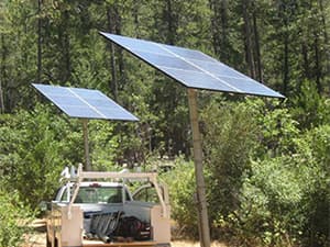 Solar Panels Near Natural Landscape Solar panels installed near wooded property providing clean renewable energy