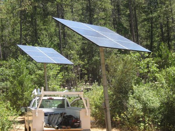 Solar Panels Near Natural Landscape Solar panels installed near wooded property providing clean renewable energy